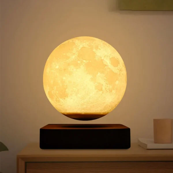 A lunar lamp emitting a warm, yellow light, placed on a wooden surface. The lamp is spherical, resembling the moon, and it appears to be levitating above a dark base. Text above reads “Lunar lamp.” A lunar lamp emitting a warm, yellow light, placed on a wooden surface. The lamp is spherical, resembling the moon, and it appears to be levitating above a dark base. Text above reads "Lunar lamp."